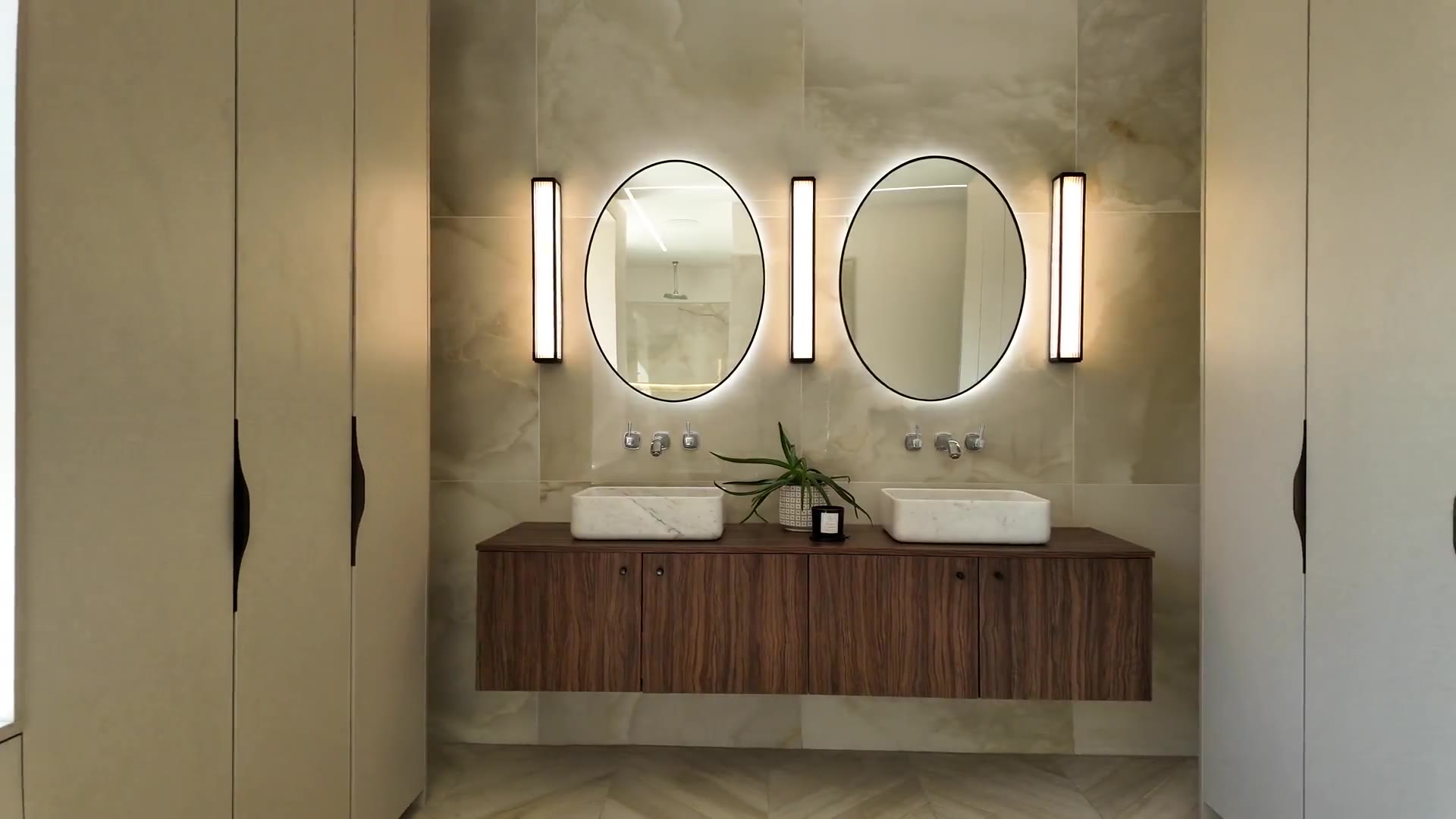 Modern bathroom with dual vanity sinks and backlit mirrors